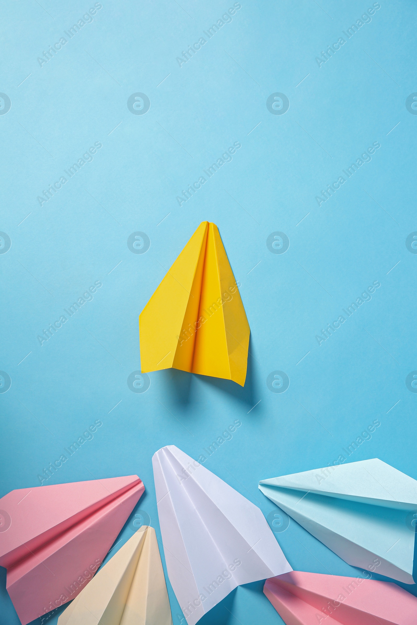 Photo of Yellow paper plane leading others on turquoise background, flat lay. Diversity concept