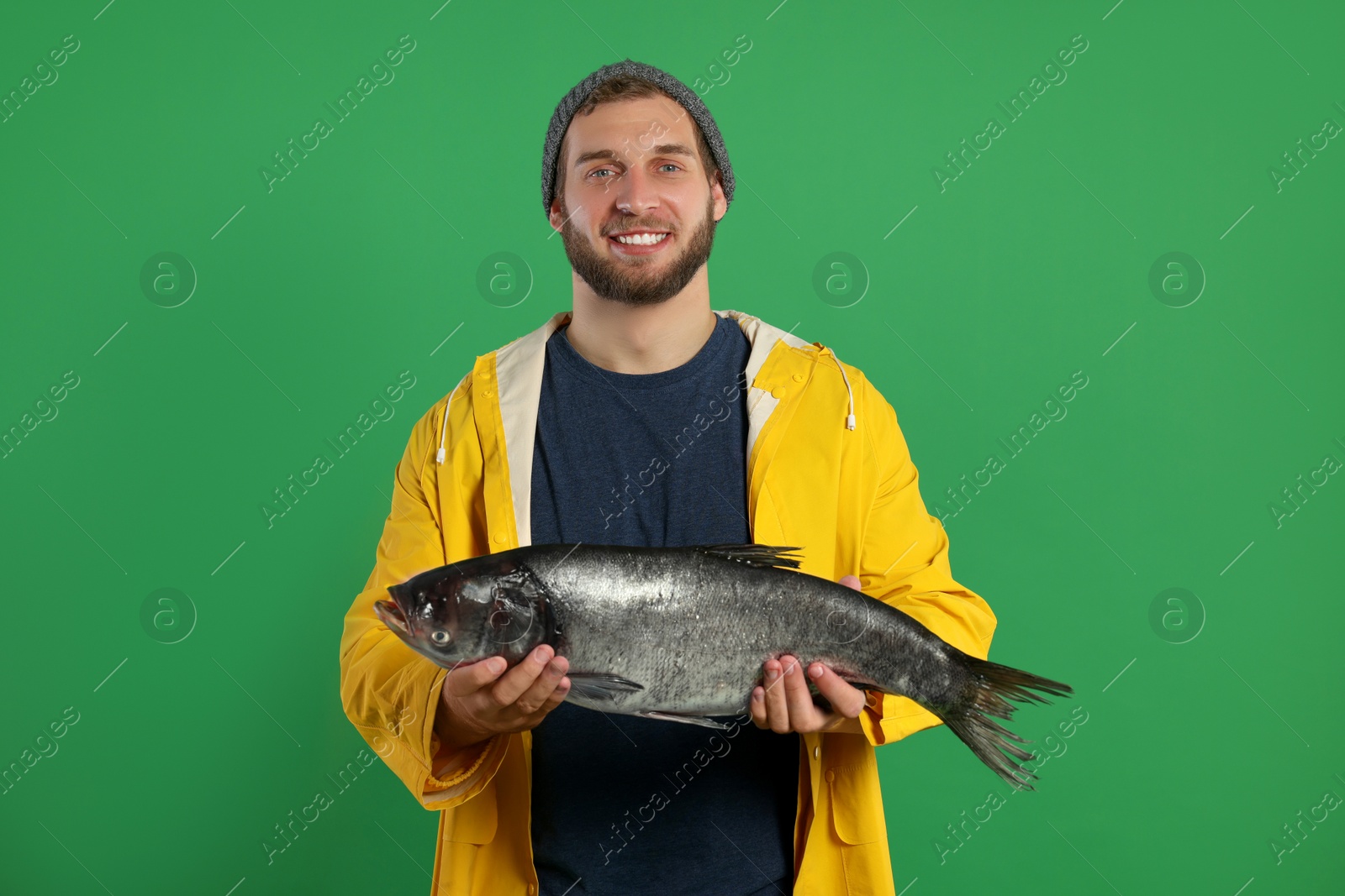 Photo of Fisherman with caught fish on green background