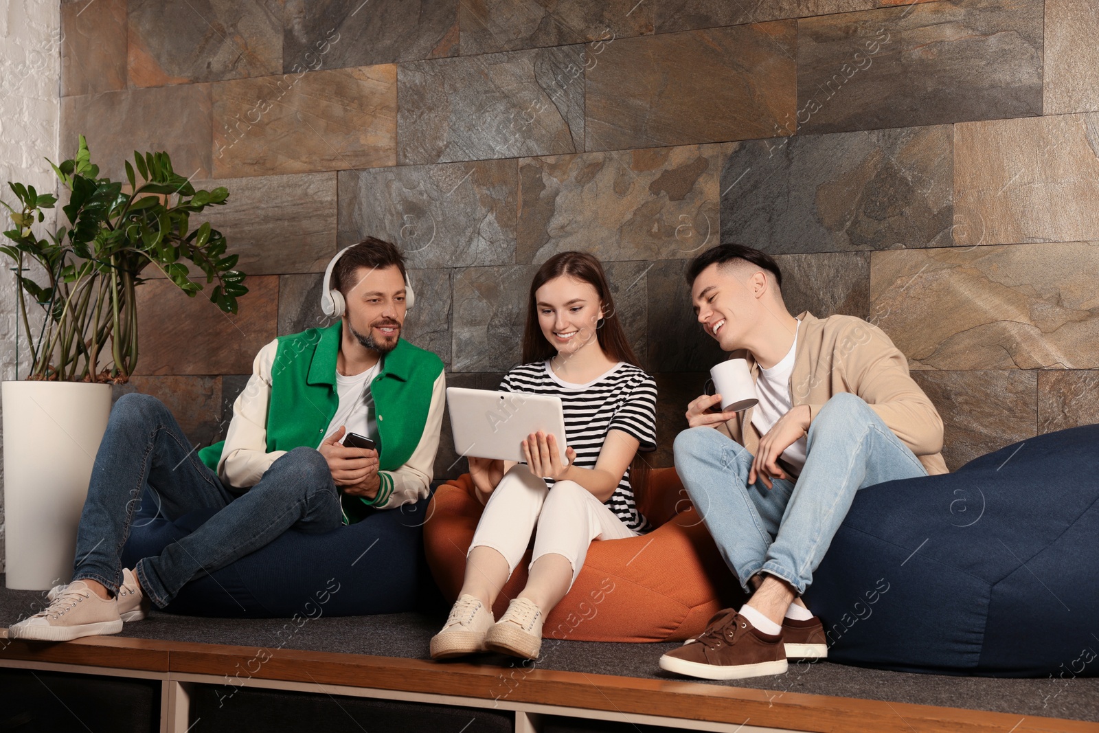 Photo of Office employees enjoying break together in recreation room at work