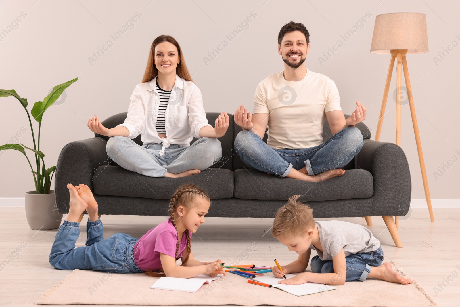 Photo of Parents meditating while their children painting at home