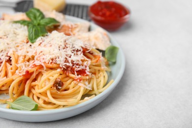 Delicious pasta with tomato sauce, basil and parmesan cheese on white table, closeup. Space for text