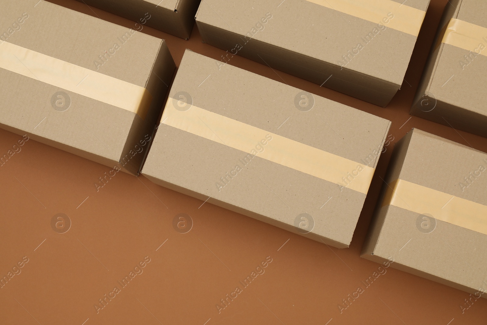 Photo of Many cardboard boxes on brown background, flat lay. Space for text