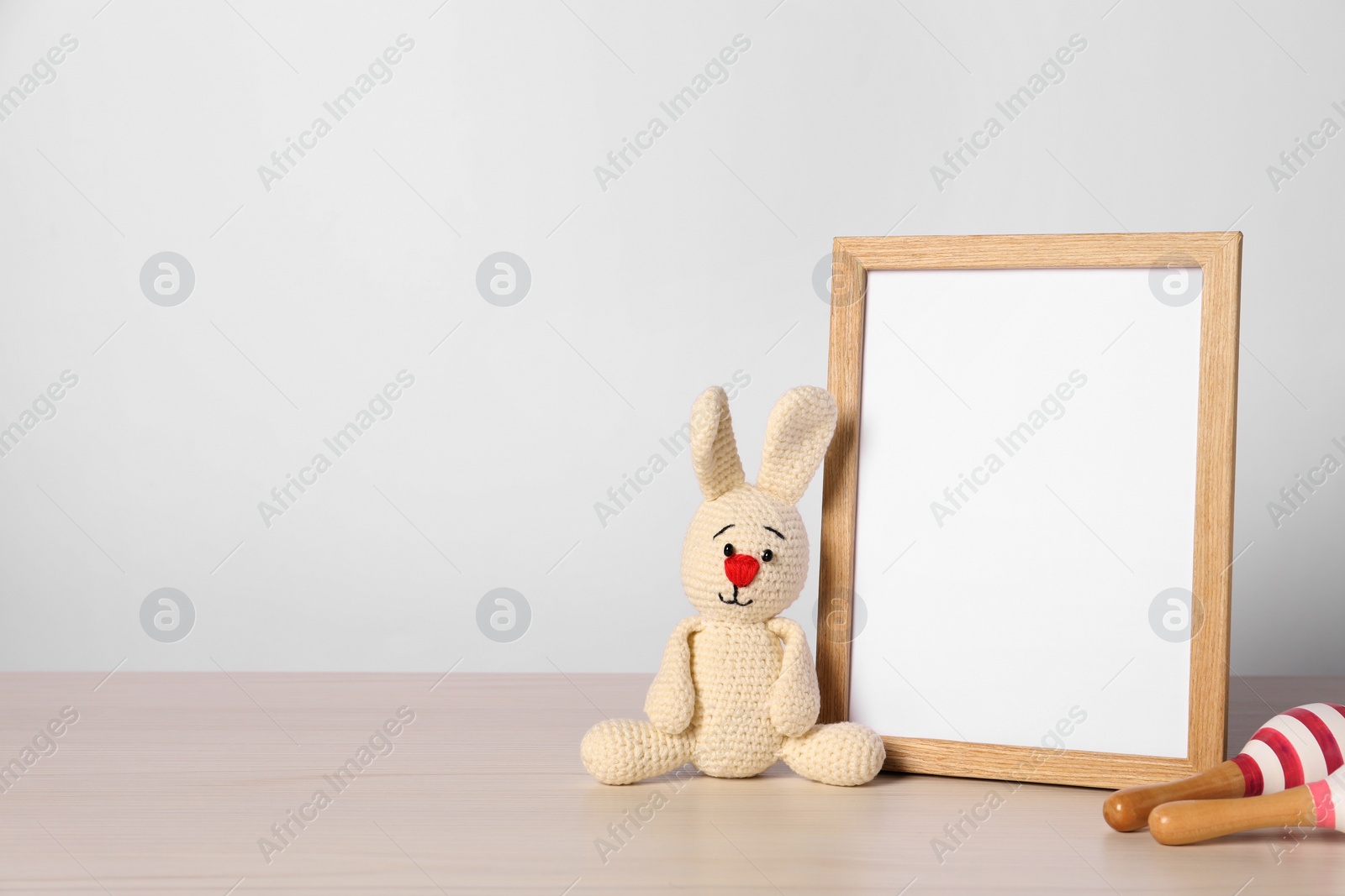 Photo of Empty square frame and different toys on white table, space for text