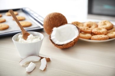 Bowl with coconut oil and nut pieces on wooden table