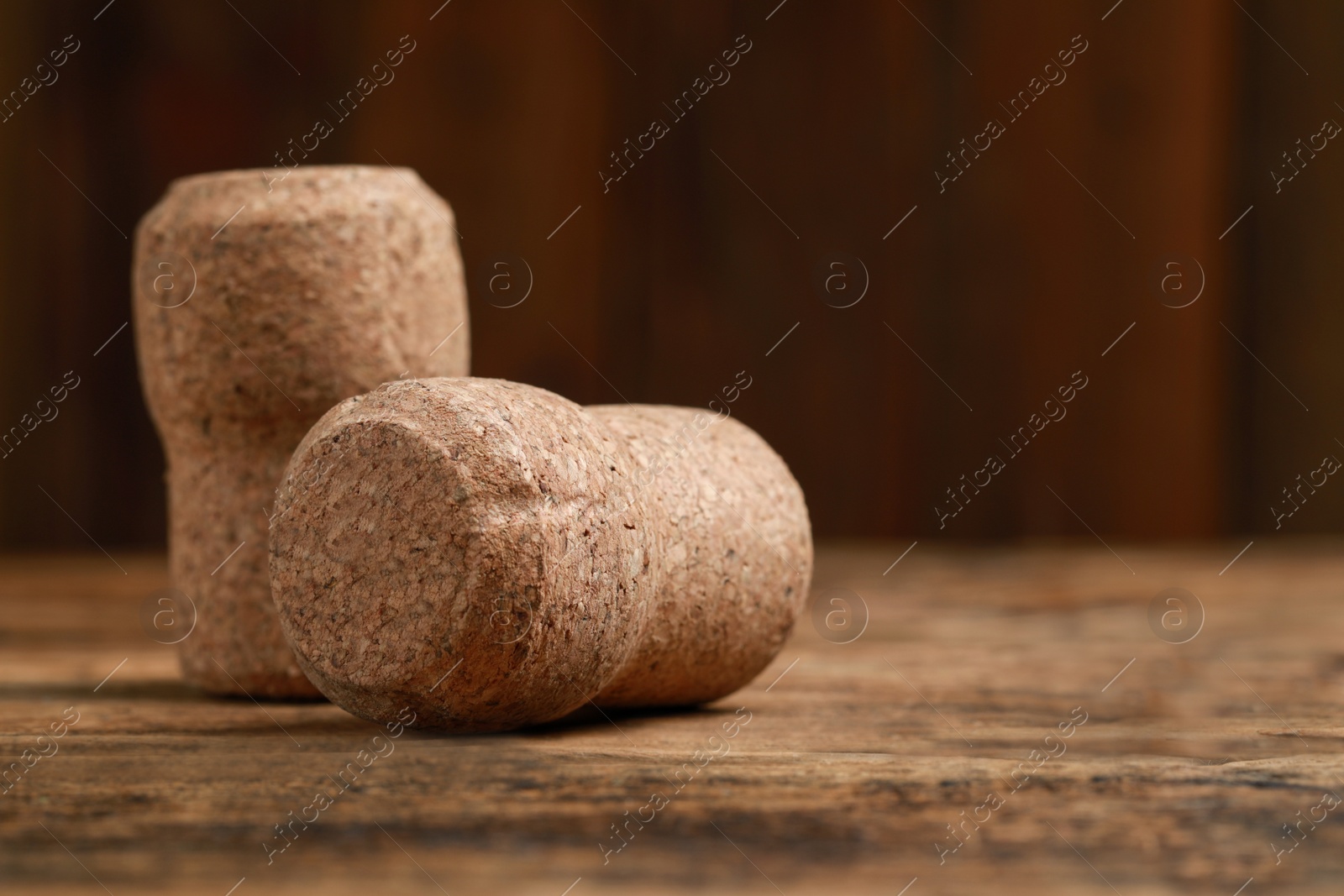 Photo of Corks of wine bottles on wooden table, closeup. Space for text