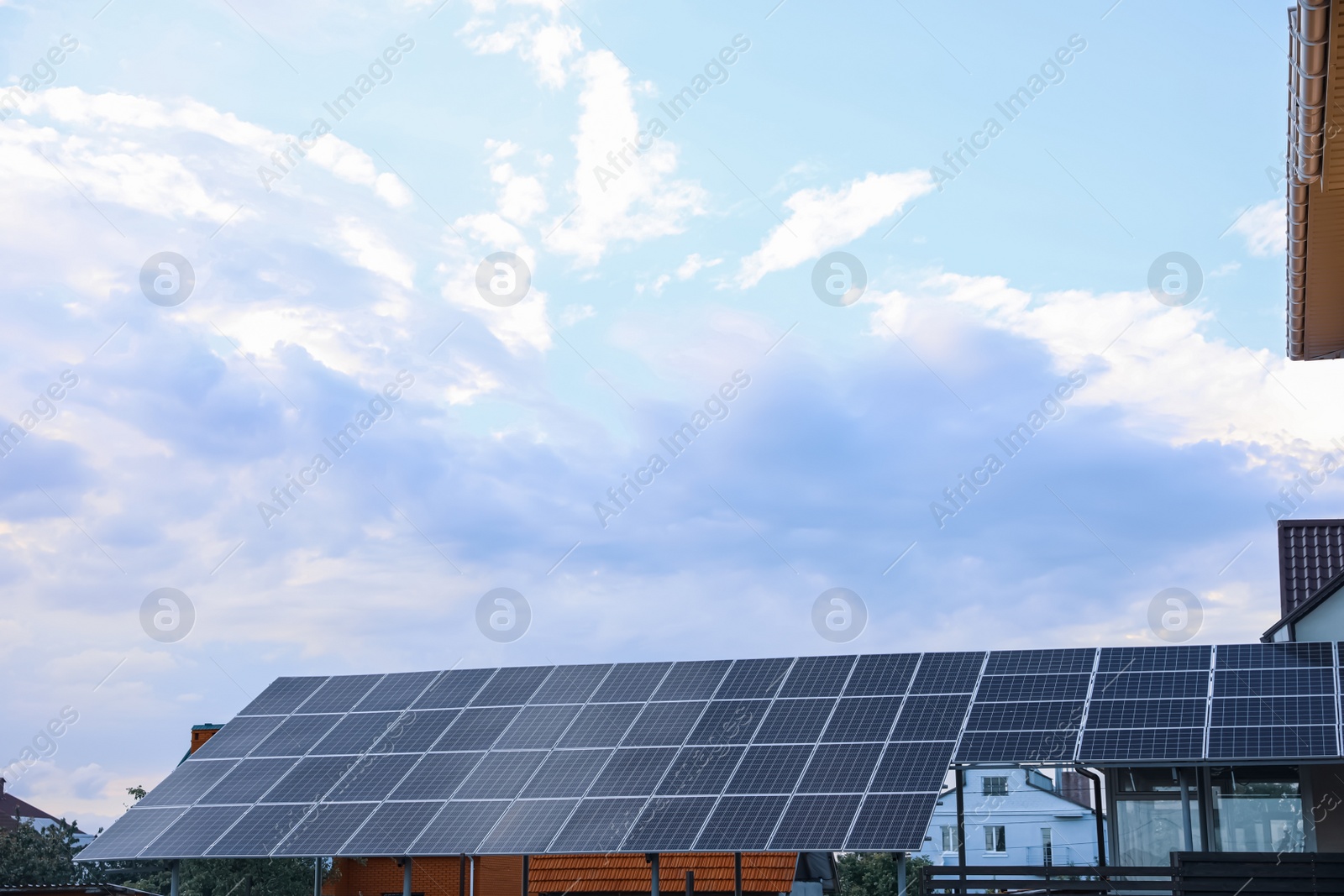 Photo of Modern solar panels installed on backyard of cottage