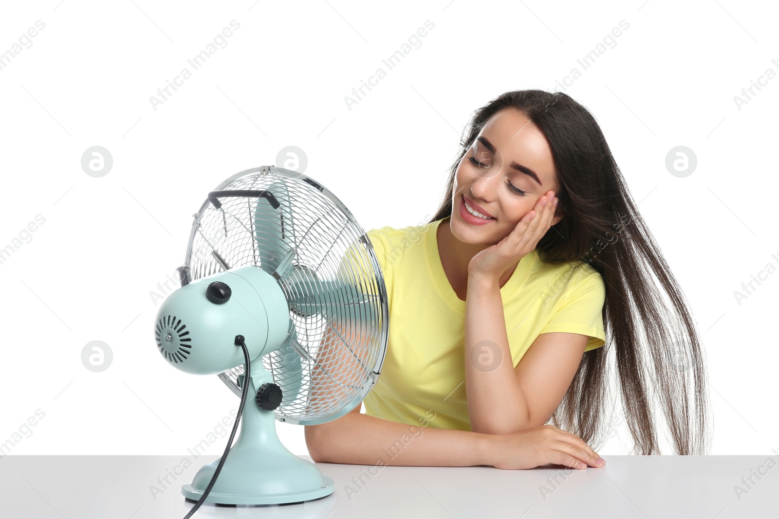 Photo of Woman enjoying air flow from fan on white background. Summer heat
