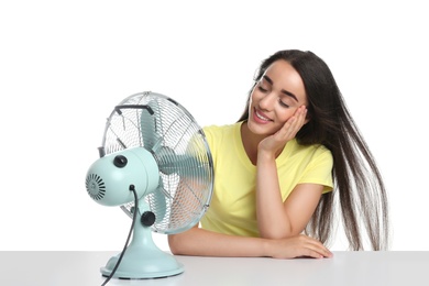 Woman enjoying air flow from fan on white background. Summer heat