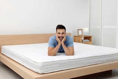 Photo of Happy man on bed with comfortable mattress at home