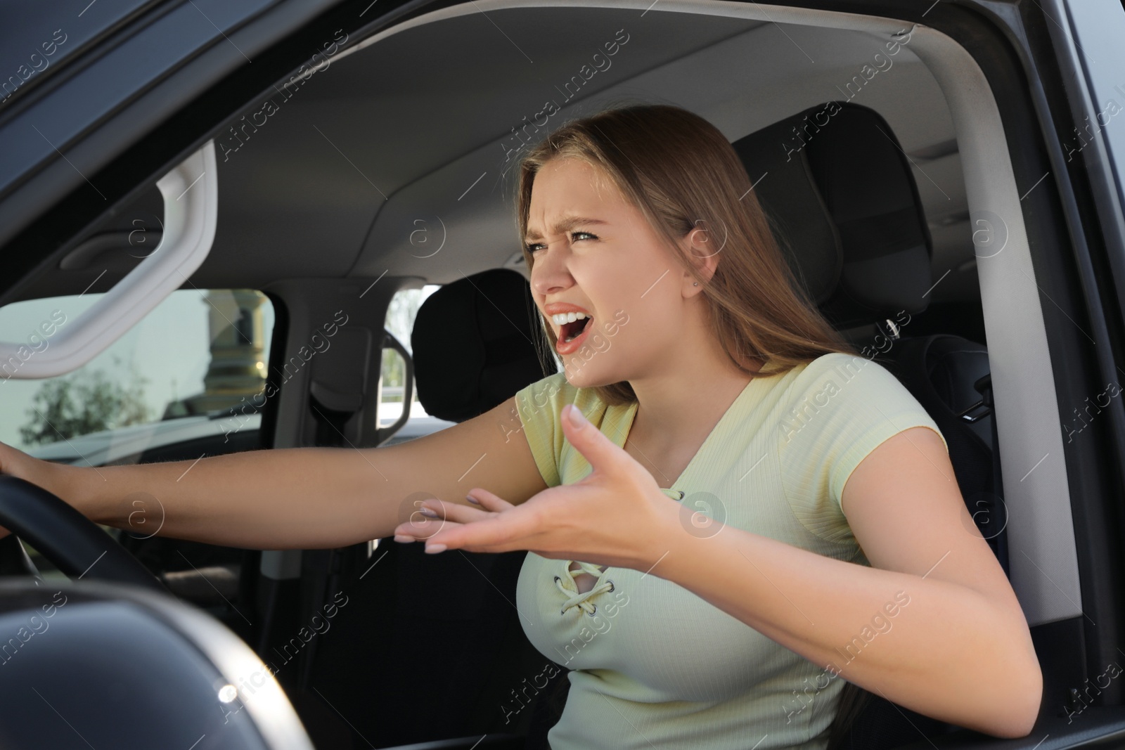 Photo of Emotional woman in car. Aggressive driving behavior