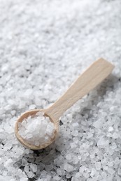 Photo of Natural salt and wooden spoon, closeup view