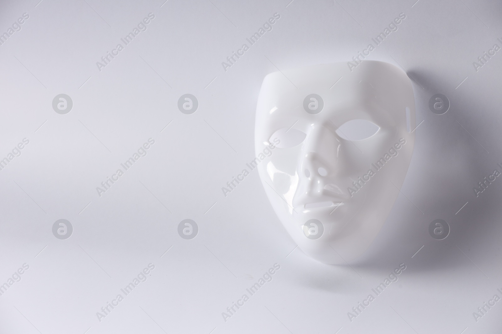 Photo of Plastic face mask on white background, space for text. Theatrical performance