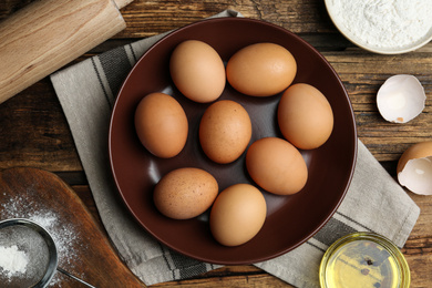 Photo of Flat lay composition with chicken eggs on wooden table