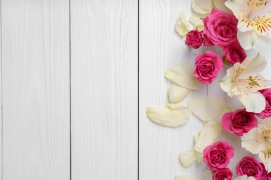 Photo of Fresh flowers on wooden background, top view with space for text