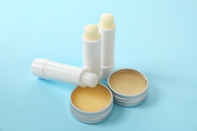 Photo of Hygienic lipsticks and balms on color background