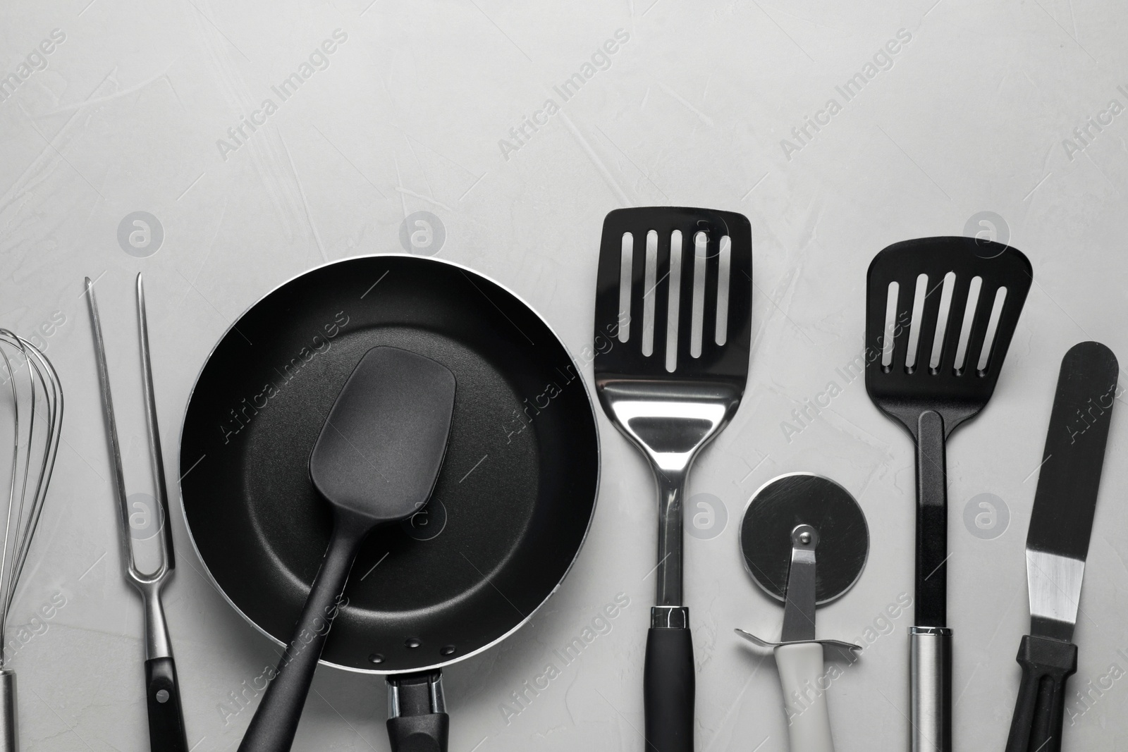 Photo of Different spatulas and other kitchen utensils on grey background, flat lay