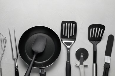 Photo of Different spatulas and other kitchen utensils on grey background, flat lay