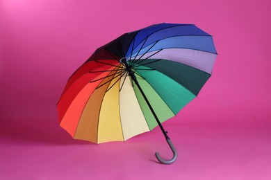 Photo of Stylish open bright umbrella on pink background