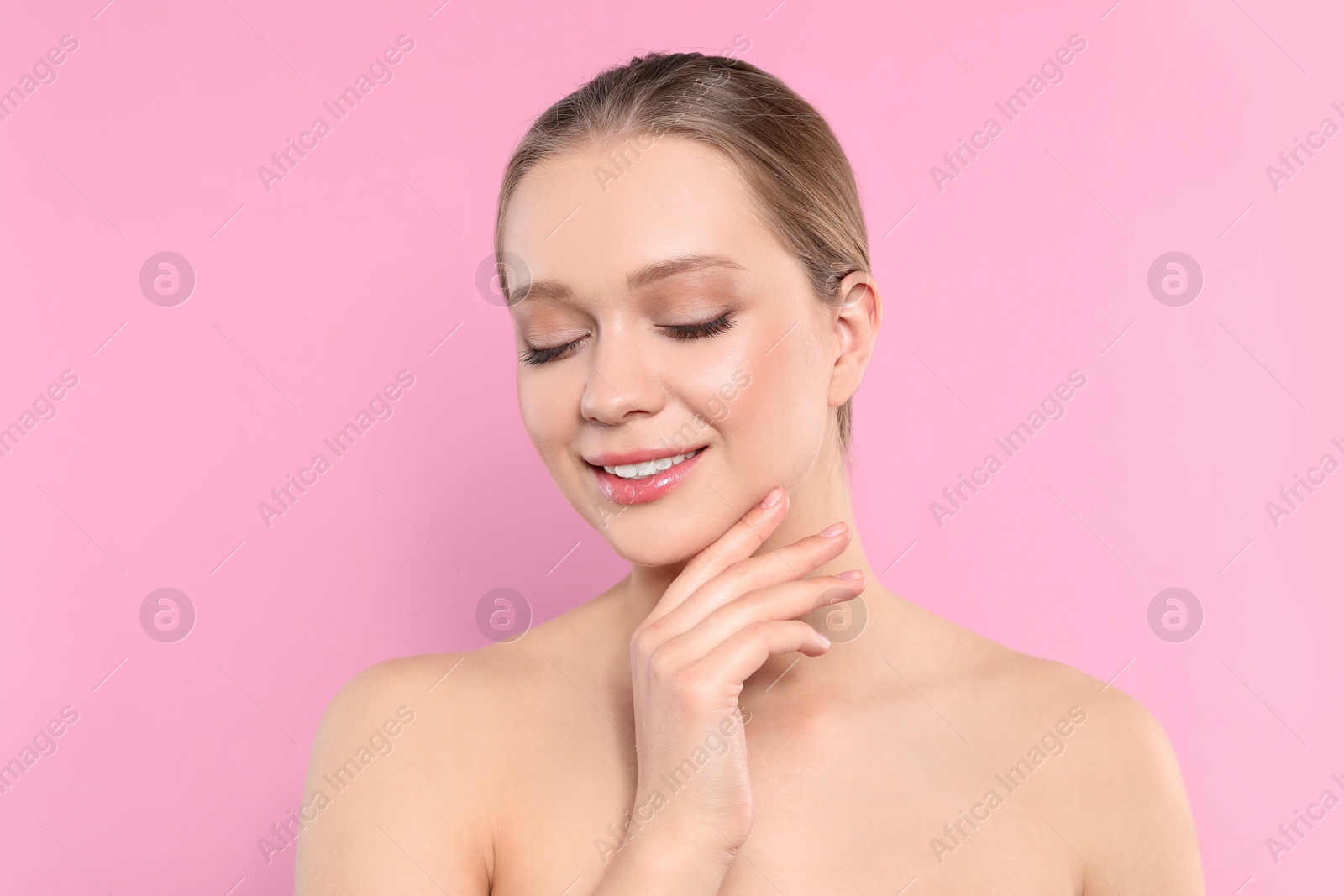 Photo of Portrait of young woman with beautiful face on pink background