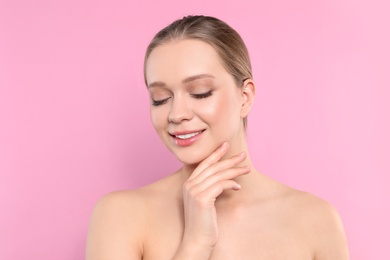 Portrait of young woman with beautiful face on pink background