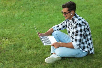 Photo of Portrait of young man with laptop outdoors
