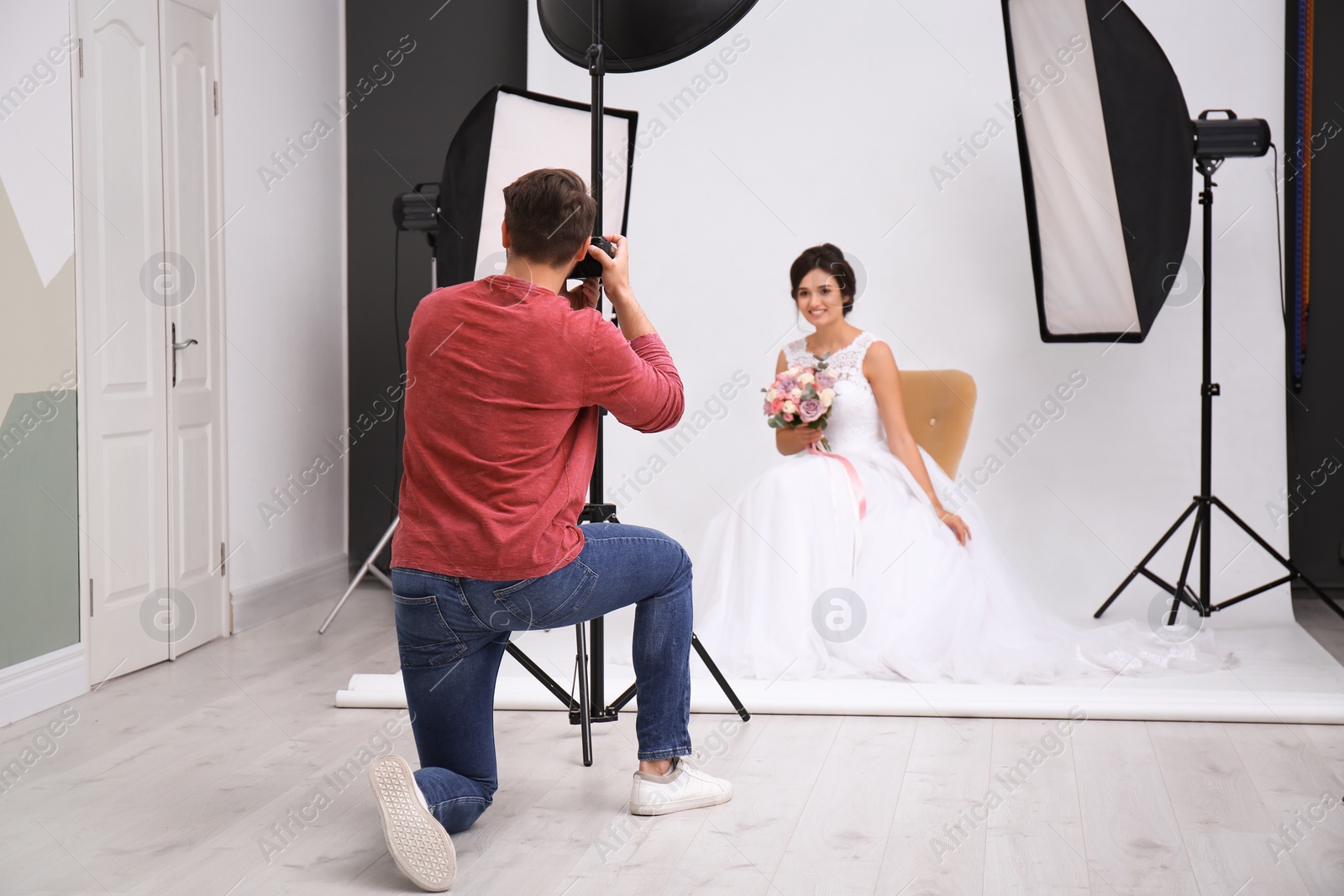 Photo of Professional photographer taking photo of beautiful bride in studio