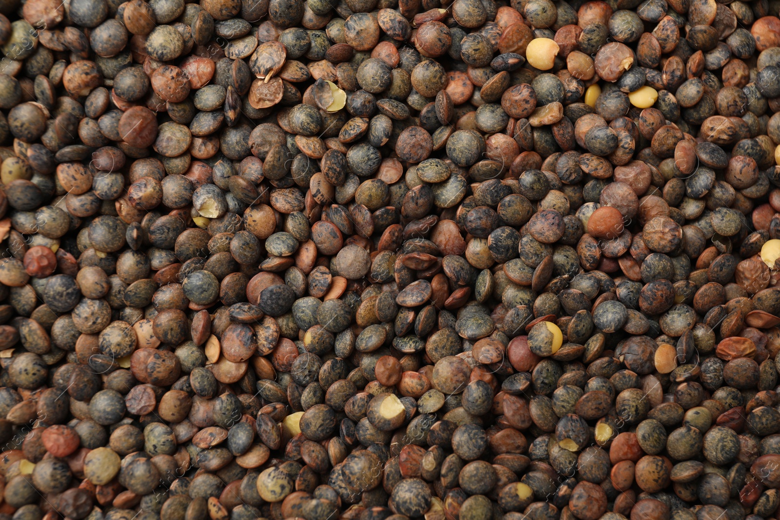 Photo of Heap of raw lentils as background, top view