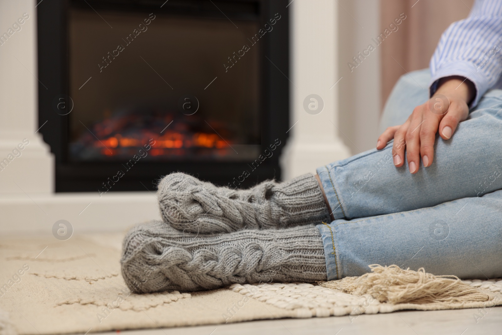 Photo of Woman resting near fireplace at home, closeup