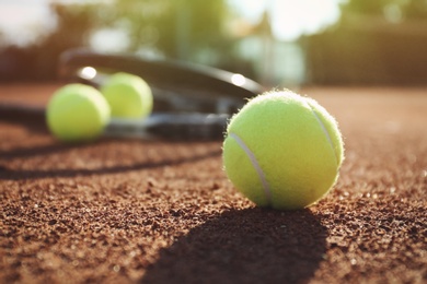Photo of Tennis balls on clay court. Space for text