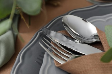 Napkin with cutlery on plate, closeup. Festive table setting