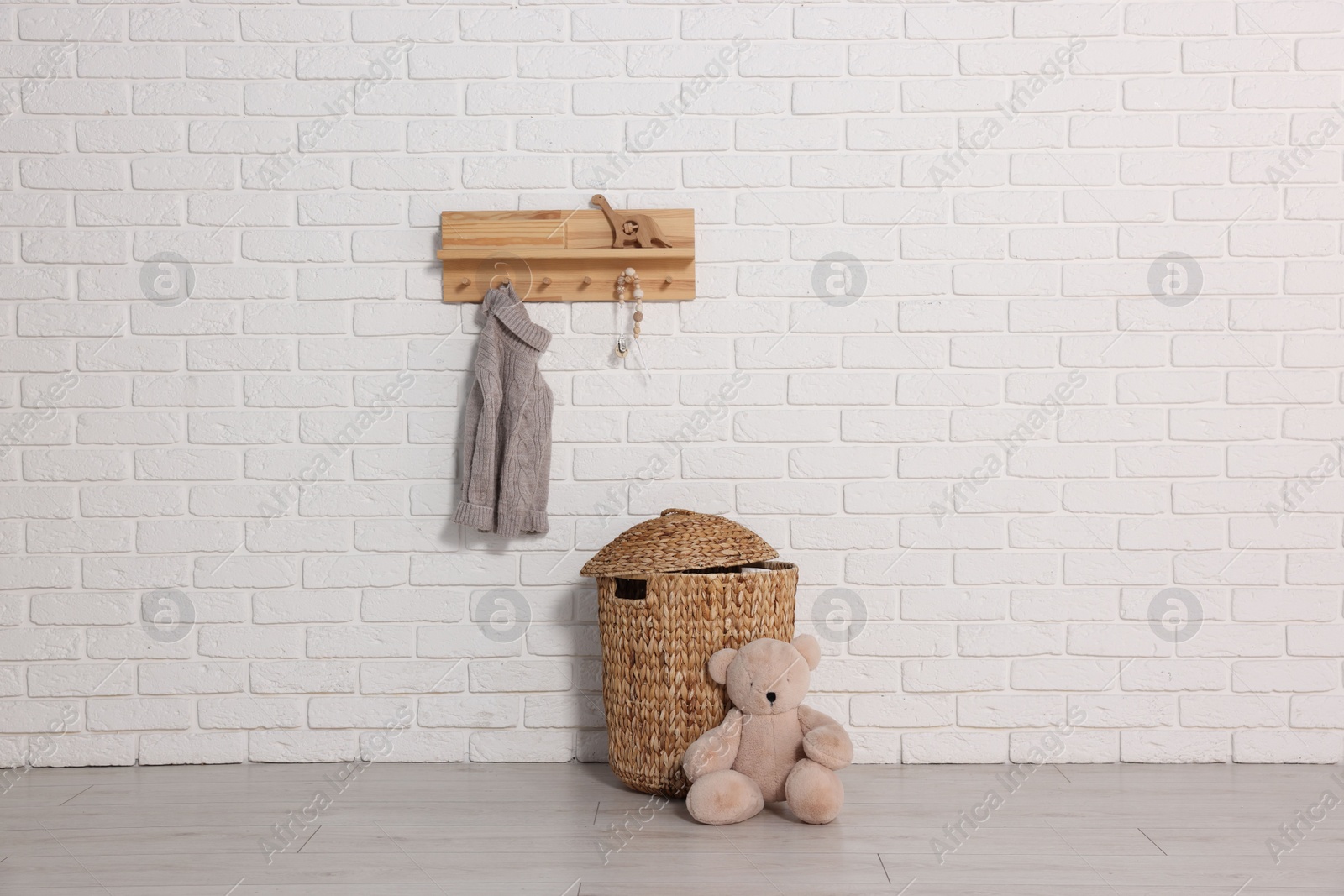 Photo of Beautiful children's room with white brick wall and toys. Interior design