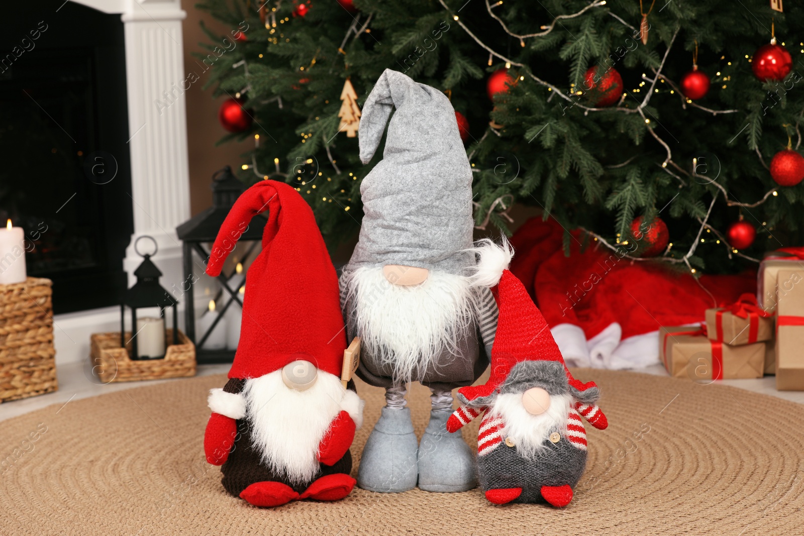 Photo of Cute decorative gnomes on floor near Christmas tree at home