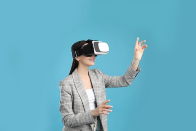 Woman using virtual reality headset on light blue background