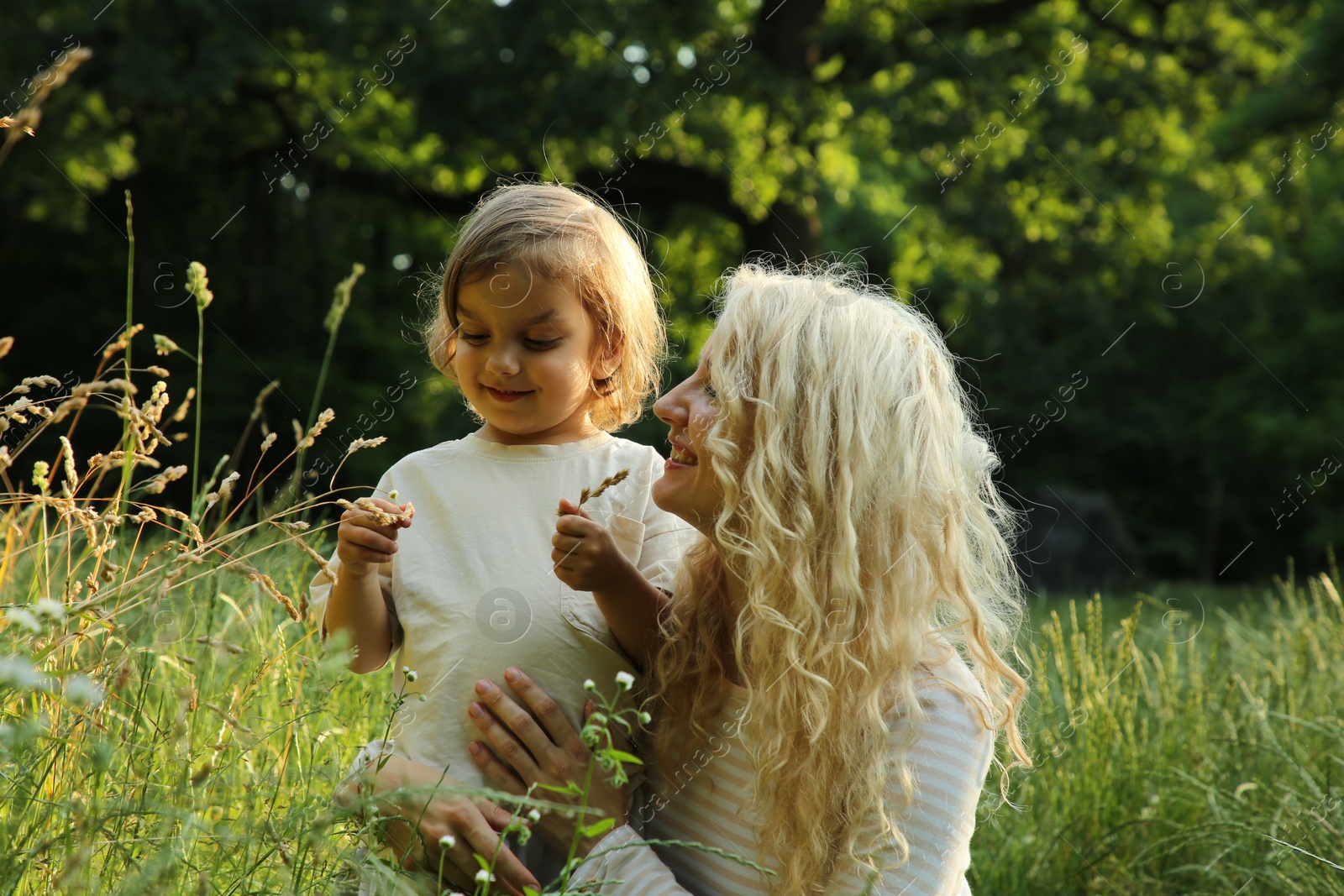 Photo of Beautiful mother with her cute daughter spending time together outdoors