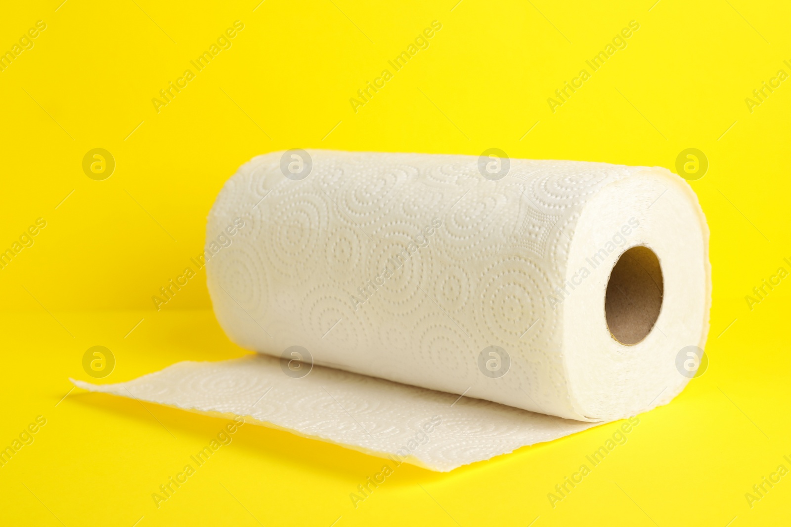 Photo of Roll of paper towels on yellow background