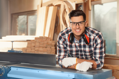 Photo of Professional carpenter near surface planer in workshop