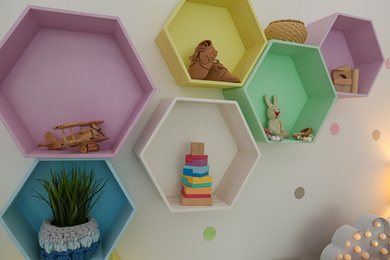 Photo of Bright colorful shelves on light wall. Interior design