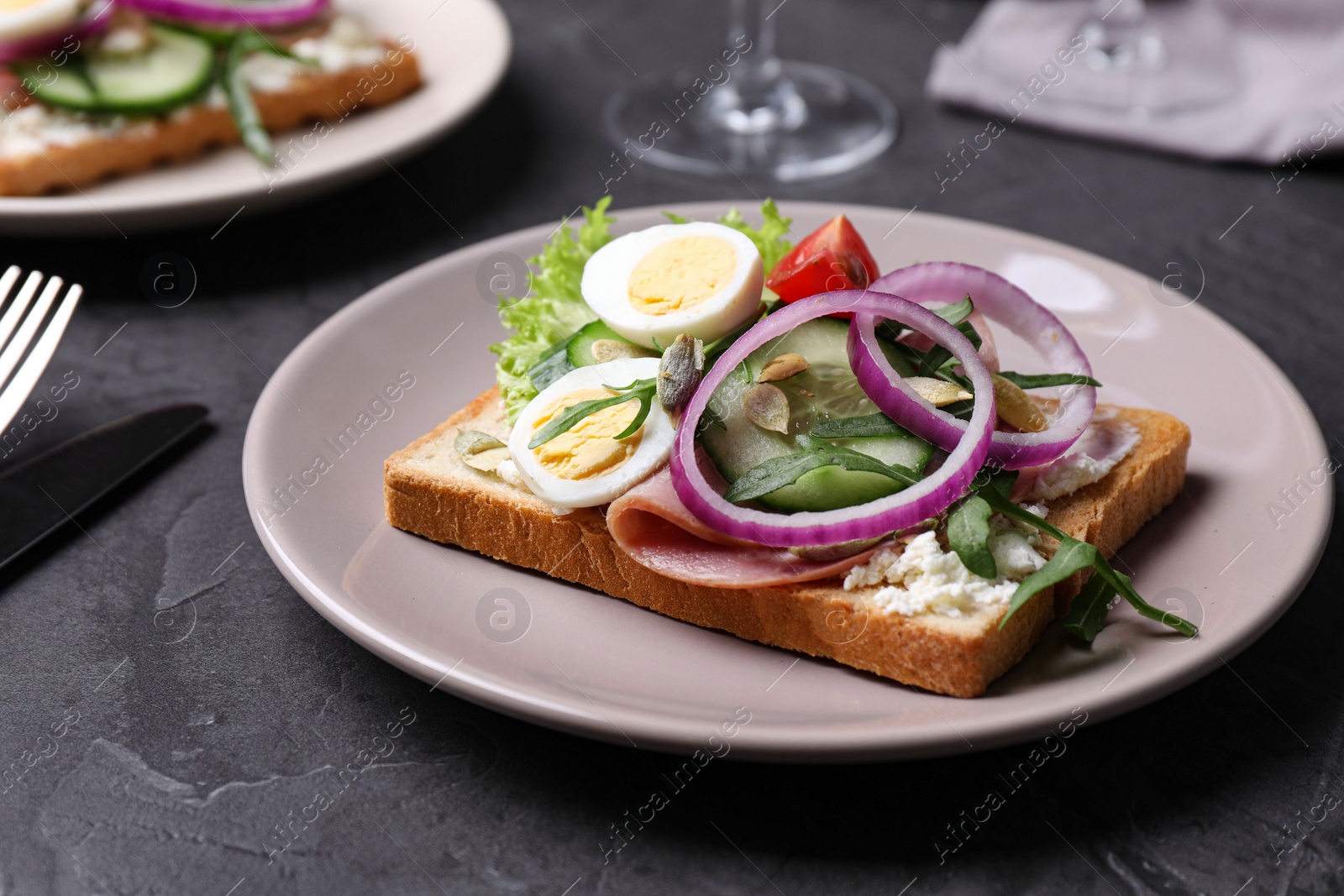 Photo of Tasty sandwich with ham and quail eggs served on grey table
