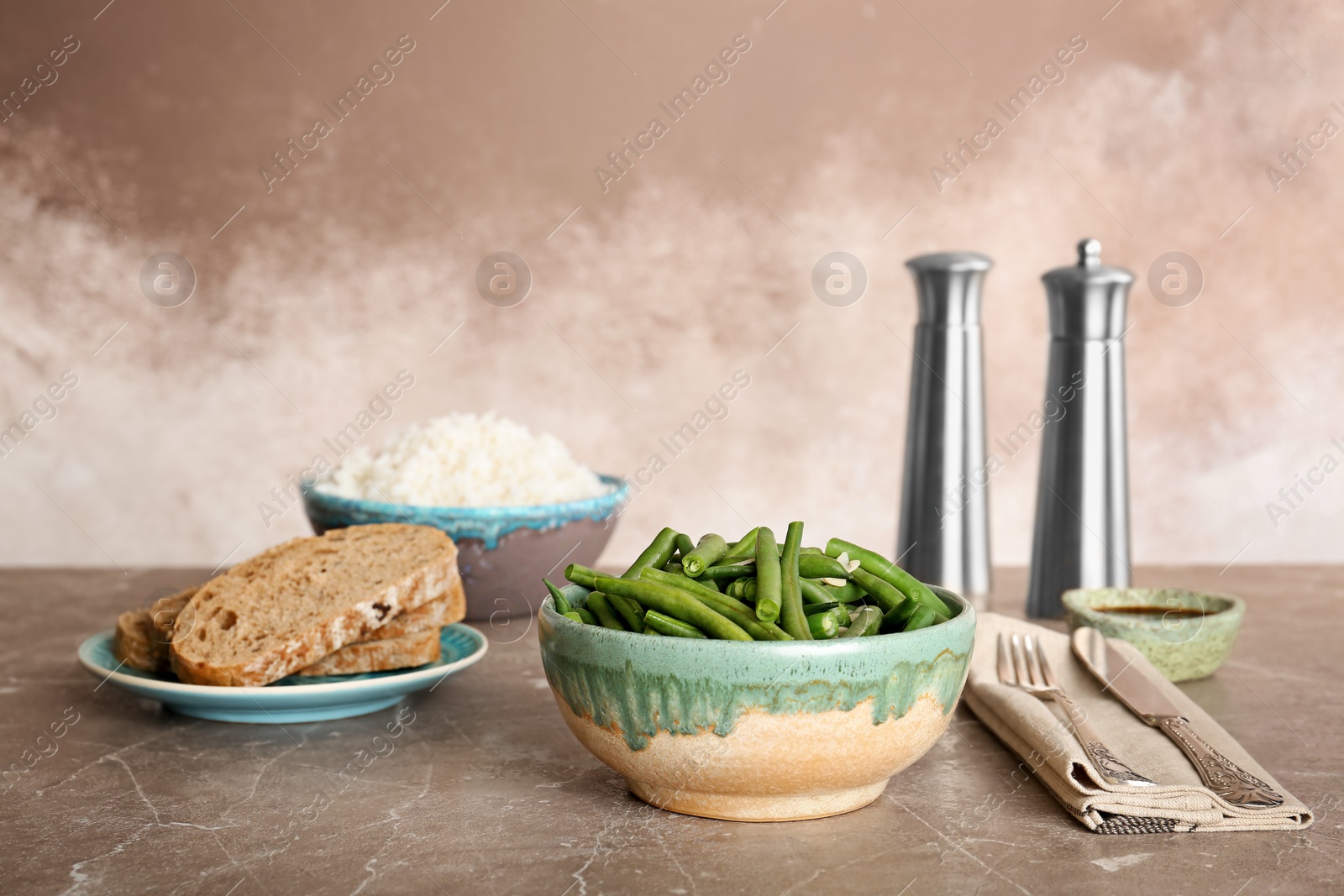 Photo of Bowl with tasty green beans on table