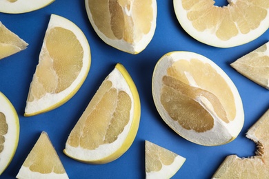 Photo of Slices of delicious ripe pomelo on blue background, flat lay