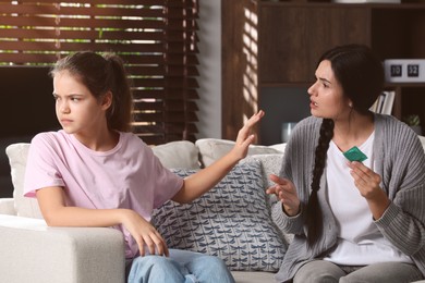 Photo of Mother talking with her teenage daughter about contraception at home. Sex education concept