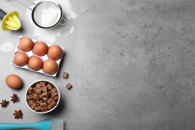 Cooking utensils and ingredients on grey table, flat lay. Space for text