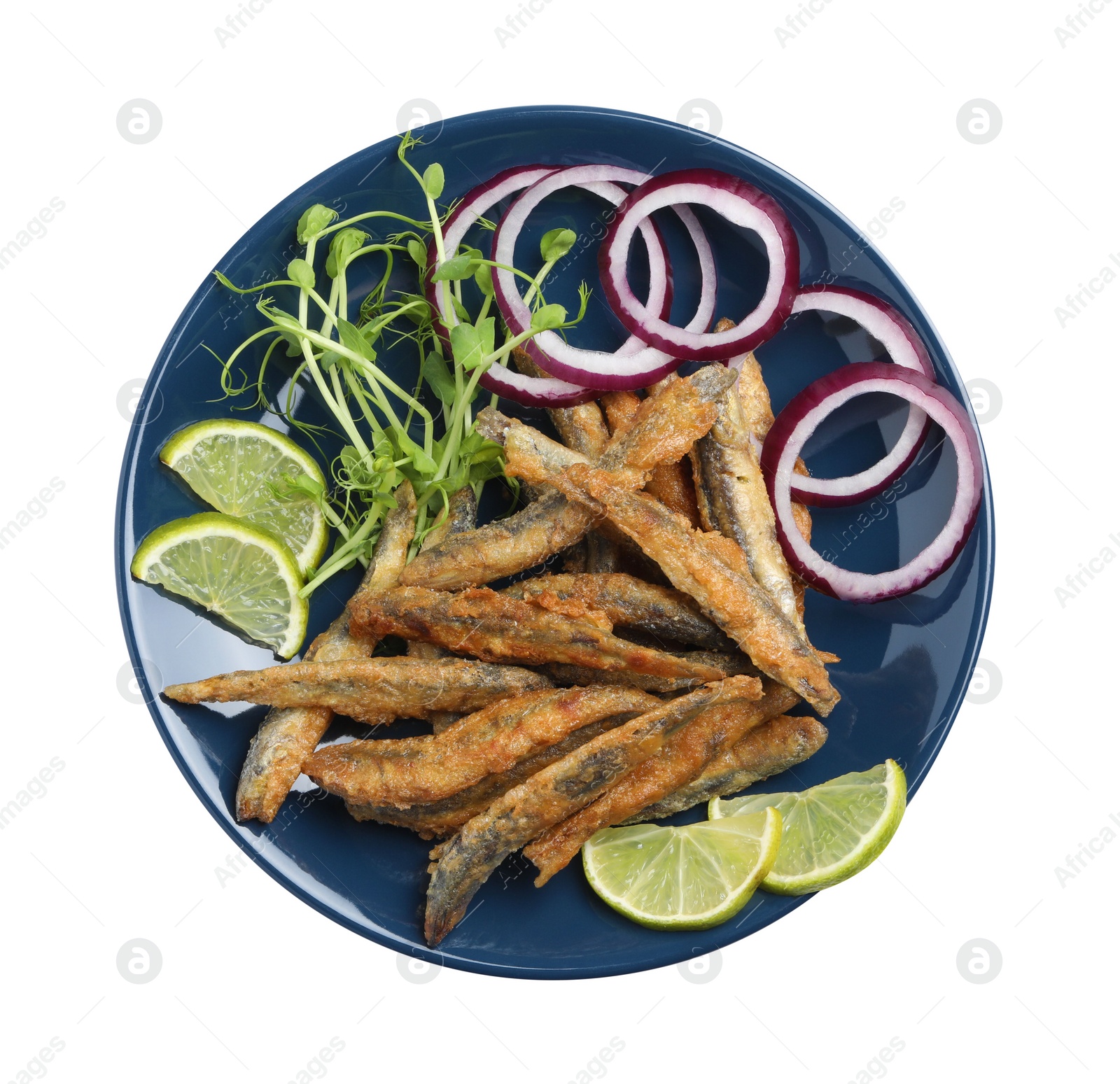 Photo of Plate with delicious fried anchovies, lime slices, microgreens and onion rings on white background, top view