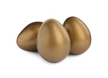 Photo of Many shiny golden eggs on white background