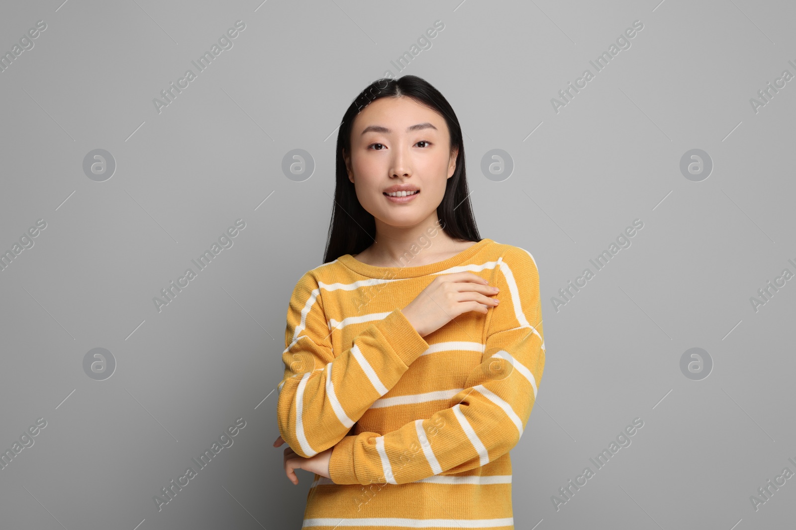 Photo of Portrait of smiling woman on grey background