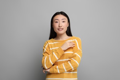 Portrait of smiling woman on grey background