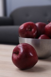 Red apples on wooden table indoors, closeup