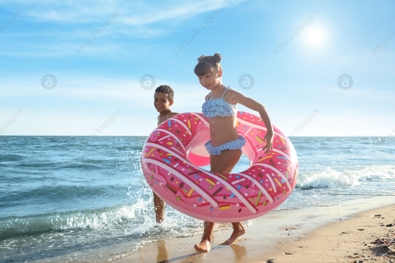 Photo of Cute children enjoying sunny day at beach. Summer camp