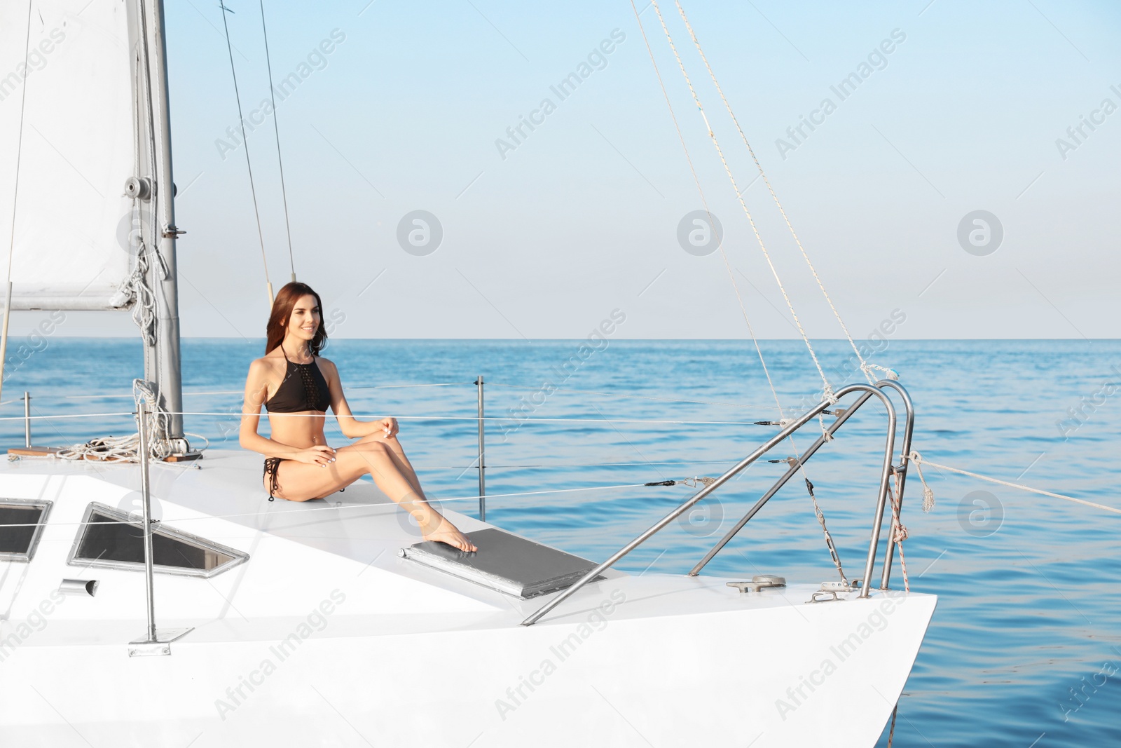 Photo of Beautiful woman in bikini relaxing on yacht during sea trip