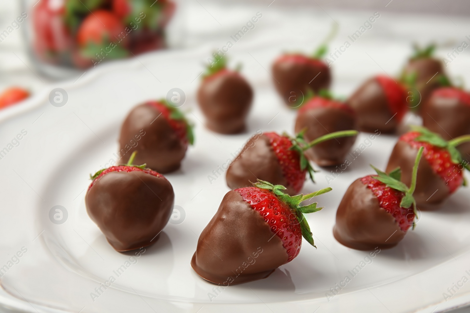 Photo of Plate with chocolate covered strawberries on table, closeup